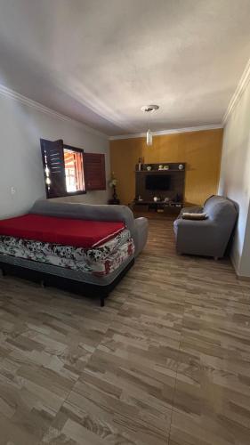 a bedroom with a bed and a couch and a chair at Casa em São Tomé das Letras in São Thomé das Letras