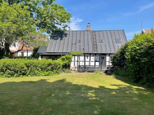 a large house with a gray roof and a yard at Gunilla's house in Huaröd in Huaröd