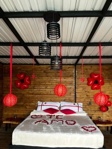 a bedroom with a bed with red lamps and red pillows at Gampling el Cielo los pinos in Rionegro