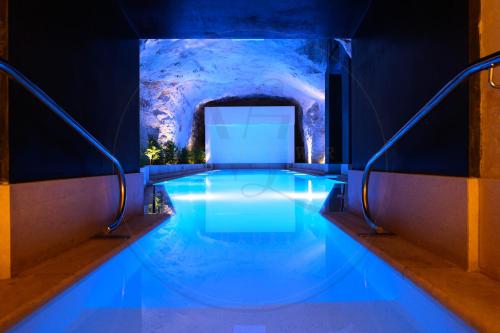 a swimming pool in a building with blue lighting at 24th Floor Luxury Sea View Apart-Hotel Pools Spa Gym & Rooftop I Mercury Tower in St. Julianʼs
