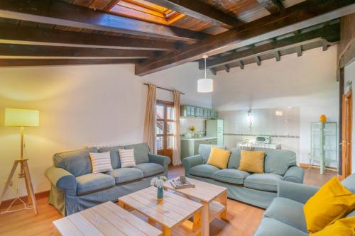 a living room with two blue couches and a table at Espaciosa casa rural en pleno corazón del Baztán in Arizcun