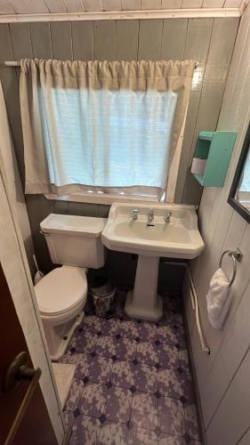 a small bathroom with a toilet and a sink at Hosteria CASA MILLER B&B FRENTE AL MAR in Bahía Mansa