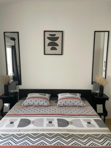 a bedroom with a bed with two pillows and two mirrors at Superbe duplex cosy in Reims