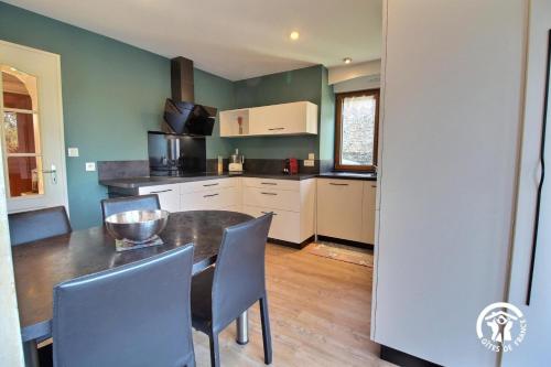a kitchen with a table and chairs in a room at Le gite du procureur in Monterblanc