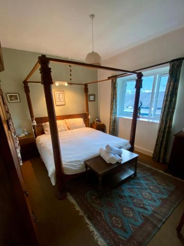 a bedroom with a canopy bed and a large window at School House in Patterdale