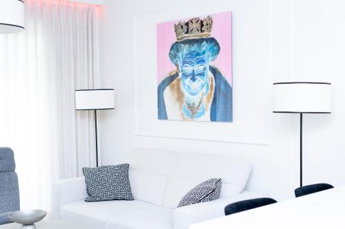 un salon avec un canapé blanc et un tableau dans l'établissement Elegancki Apartament Park Bażantów, à Katowice