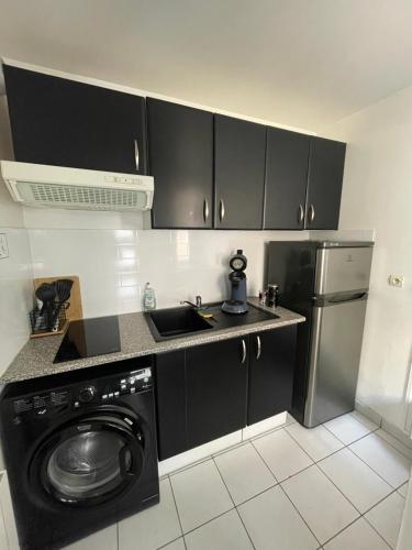 a kitchen with a washing machine and a refrigerator at Superbe duplex cosy in Reims