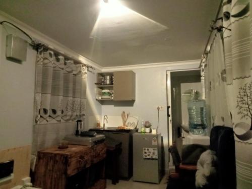 a kitchen with a light on the ceiling and a refrigerator at Acacia Square & Camping in Kitengela 