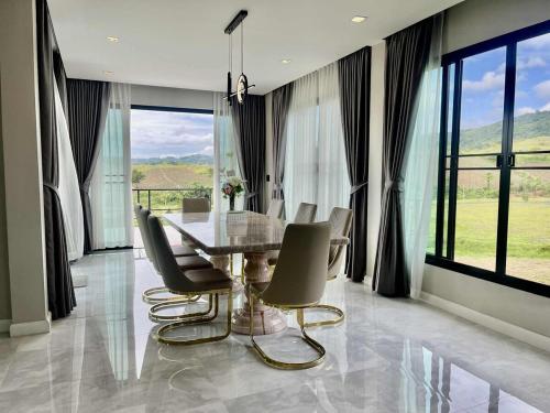 a dining room with a glass table and chairs at Cloud N Wind Khao Kho Thailand in Ban Lao Kok Kho