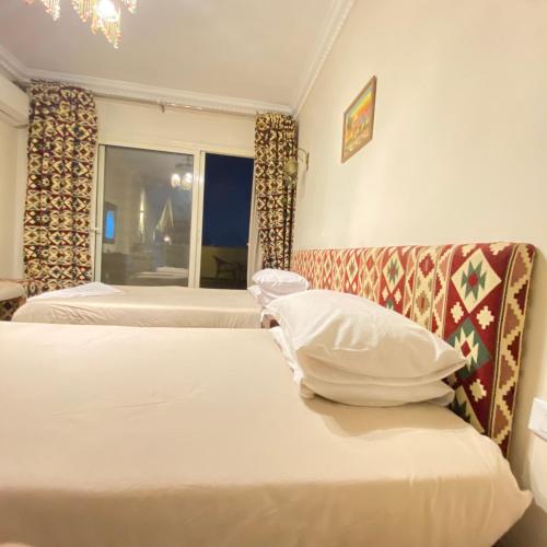 a hotel room with two beds and a window at Five Pyramids Peaks View in Cairo