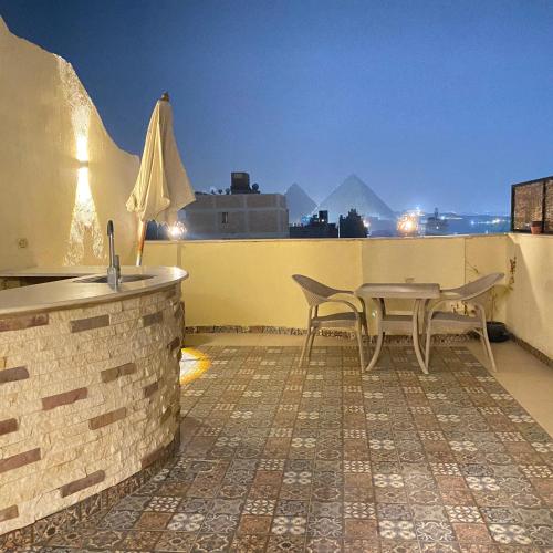 a patio with a table and chairs on a roof at Five Pyramids Peaks View in Cairo