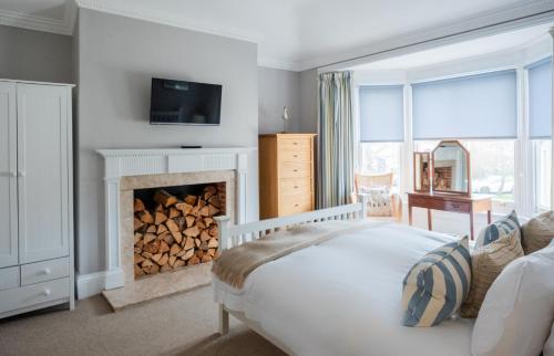 a bedroom with a fireplace with a tv above it at The Brewer's House in Southwold