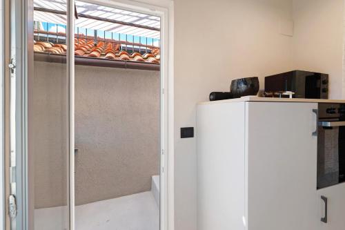 a kitchen with a sliding glass door and a refrigerator at Torri e tramonti in Albenga