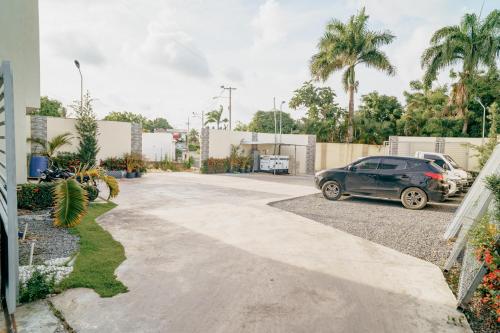a car parked in a parking lot with palm trees at HOTEL K2 in Higuey