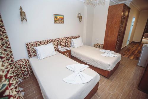 a small room with two beds and a chair at Five Pyramids Peaks View in Cairo