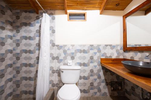 a bathroom with a toilet and a sink at Hospedaje La Quebrada in Máncora