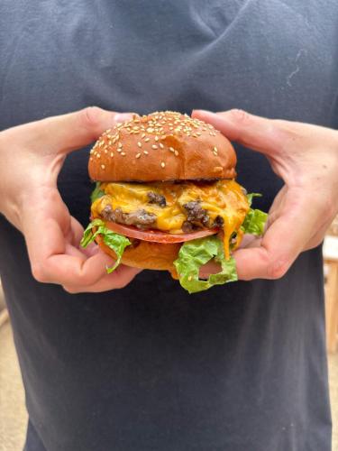 a man holding a hamburger in his hands at The Market Tavern in Bampton