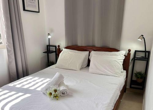 a bedroom with a white bed with flowers on it at Villa Monte Azul in Willemstad