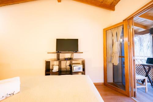 a bedroom with a bed and a tv and a window at Hospedaje La Quebrada in Máncora