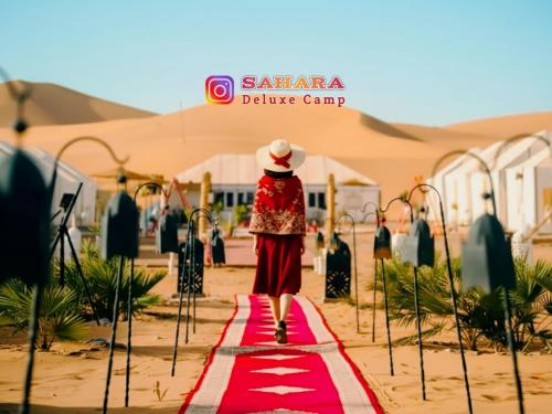 a woman is walking down a red carpet at Sahara Deluxe Camp in Merzouga