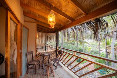 a balcony with a chandelier and a table and chairs at Hospedaje La Quebrada in Máncora
