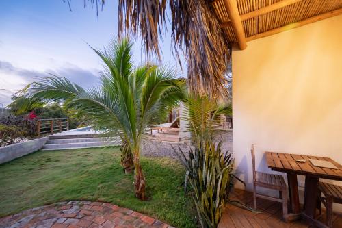 a patio with two palm trees and a table at Hospedaje La Quebrada in Máncora