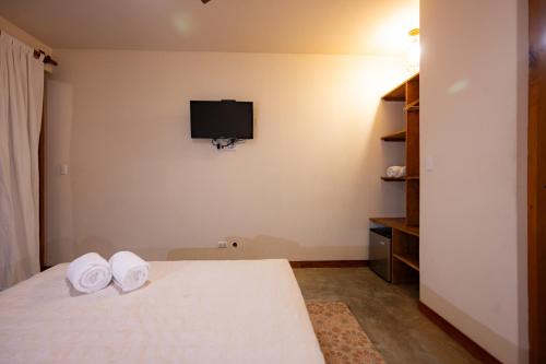 a bedroom with a bed and a tv on the wall at Hospedaje La Quebrada in Máncora