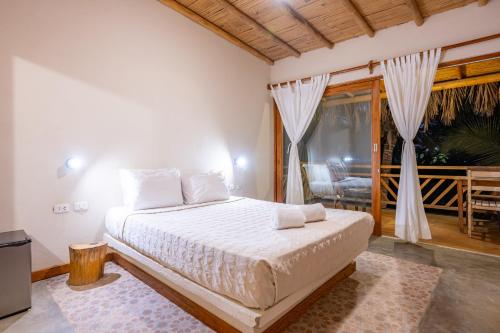 a bedroom with a bed and a balcony at Hospedaje La Quebrada in Máncora