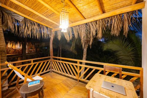 a room with a table and a laptop on a porch at Hospedaje La Quebrada in Máncora