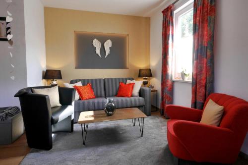 una sala de estar con un sofá y dos sillas en Upland-Flair Ferienwohnung ABENDROT im Zentrum!, en Willingen