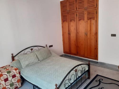 a bedroom with a bed and a wooden cabinet at Chambre au centre de Rabat in Rabat