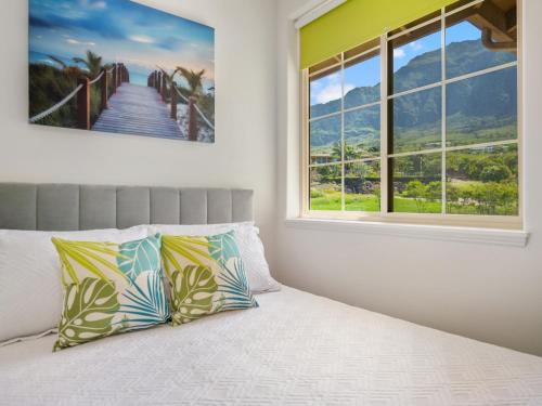 a bedroom with a bed with a view of a bridge at Kalo Homes - Makaha Modern in Makaha Valley
