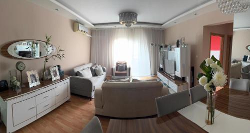 a living room with a couch and a chair and a television at Apartamento na centralidade do Kilamba-Luanda in Cope