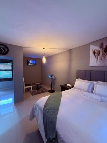 a bedroom with a large bed and a tv at Ella Guest House in Pretoria