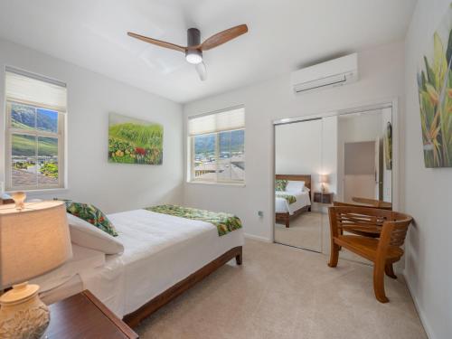 a bedroom with a bed and a desk and a window at Kalo Homes - Immersed in Aloha in Makaha Valley