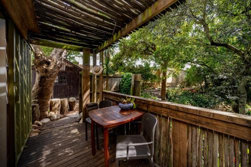 a wooden table on a deck with a pergola at Camps Bay Forest Pods in Cape Town