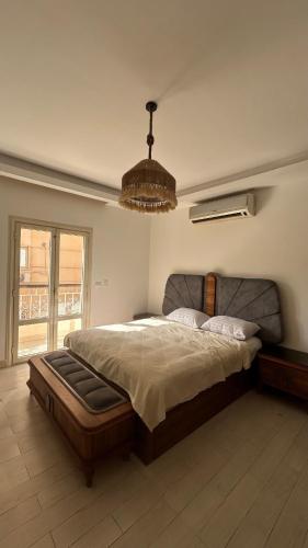 a bedroom with a large bed with a chandelier at Modern apartment near AUC - 3BR in Cairo