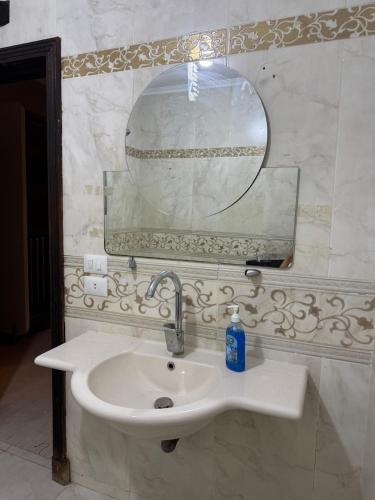 a bathroom with a sink and a mirror at Modern apartment near AUC - 3BR in Cairo