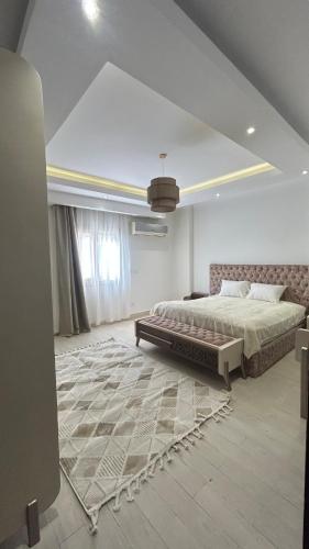 a large bedroom with a bed and a rug at Modern apartment near AUC - 3BR in Cairo