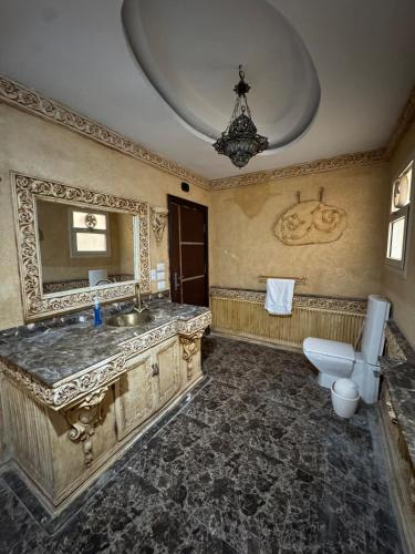 a bathroom with a sink and a toilet and a mirror at Modern apartment near AUC - 3BR in Cairo