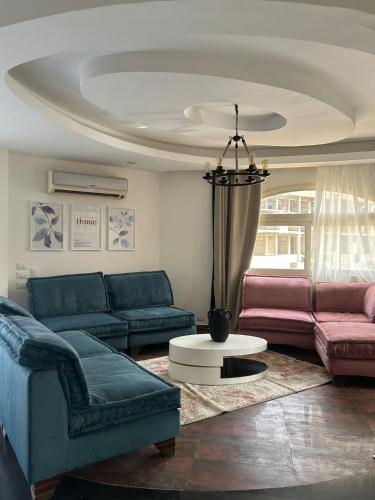 a living room with two couches and a table at Modern apartment near AUC - 3BR in Cairo