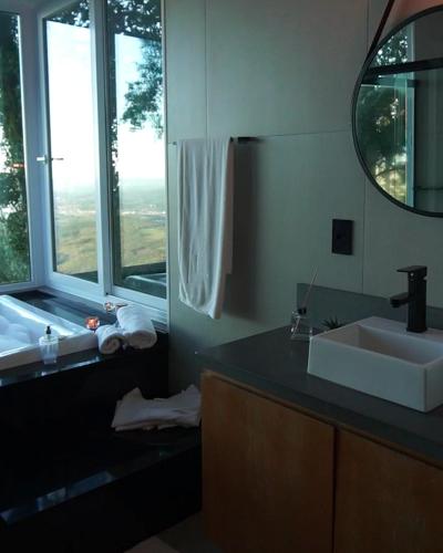 a bathroom with a sink and a mirror at HOSPEDE-SE EM UM CONTAINER AO LADO DE GRAMADO - RS in Igrejinha
