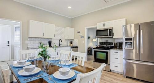 a kitchen with a table with chairs and a refrigerator at Mins to Downtown, Hospital, Airport in Greenville