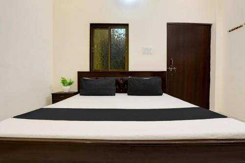 1 dormitorio con 1 cama grande con sábanas blancas y negras en Hotel O Yatharth Inn Paying Guest House, en Varanasi