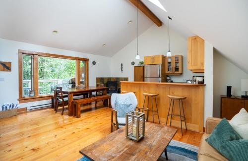 un soggiorno con tavolo e cucina di South Swell Tofino (formerly Blue Heron Waterfront Home amid Old Growth Cedars) a Tofino