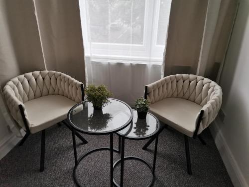 two chairs and a table in a room with a window at Chiswick Court Hotel in London