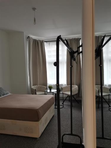 a bedroom with a bed and a room with chairs at Chiswick Court Hotel in London