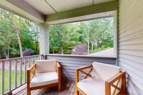two chairs on a porch with a large window at Serenity Woods Family Retreat in Glen Lord