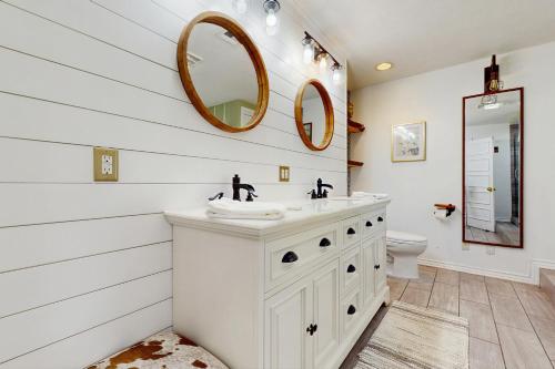 a white bathroom with a sink and a mirror at Serenity Woods Family Retreat in Glen Lord