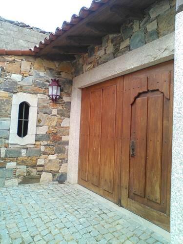 a wooden garage door on a stone building at Casa Rural Santa Teresinha in Campo de Víboras